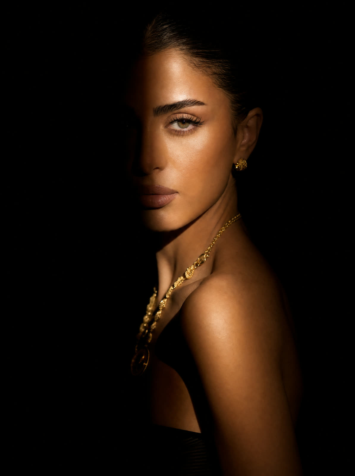 Lumière style sample — spotlight portrait emerging from darkness